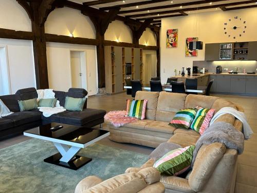 a large living room with couches and a kitchen at Ferienwohnung Ottenhof in Verden