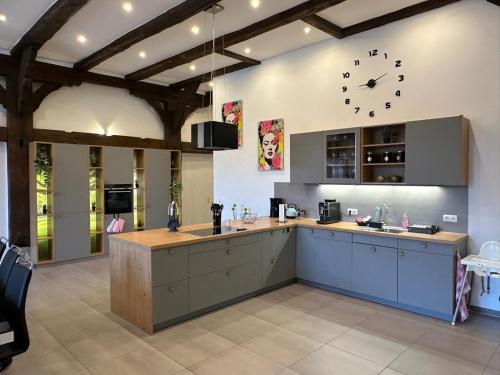 a large kitchen with a clock on the wall at Ferienwohnung Ottenhof in Verden