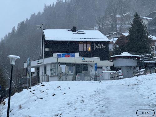 a building with snow on the roof in a town at Haus am Lift - TOP2 - Summercard included - Ski-in Ski-out - 6P in Zell am See
