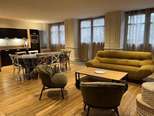 un salon avec un canapé, une table et des chaises dans l'établissement Appartement 12 pers. neuf, centre-ville avec 5 chambres et local à ski - FR-1-234-289, à Cauterets