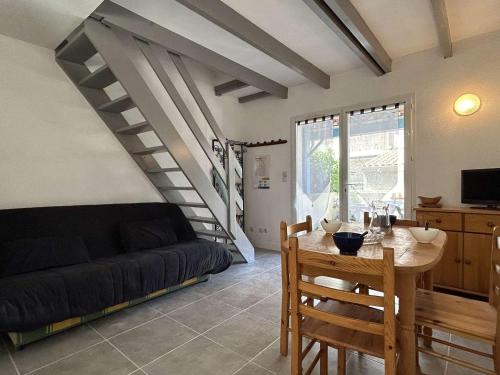 un salon avec une table et un canapé dans l'établissement Maison T2 mezzanine rénovée - 6 pers, Gruissan Mateille, Terr. ensoleillée, piscine, parking privé - FR-1-229-836, à Gruissan