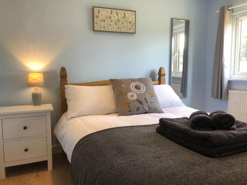 a bedroom with a bed with a ottoman on it at Nightjar Lodge - Adults Only in Lackford