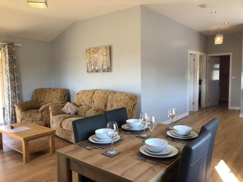 a living room with a table and a couch at Nightjar Lodge - Adults Only in Lackford