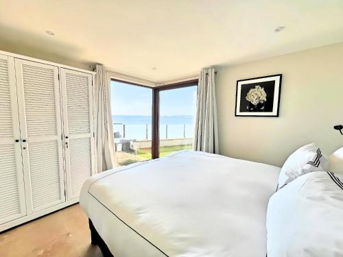 une chambre avec un grand lit et une grande fenêtre dans l'établissement Villa Marsa - Cannes - on beach, à Cannes