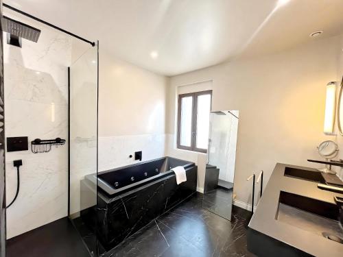 une salle de bain avec baignoire et douche en verre dans l'établissement Villa Marsa - Cannes - on beach, à Cannes