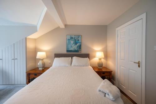 a bedroom with a large white bed with two lamps at Coach Hill House in Cork