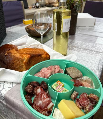 un récipient vert contenant de la nourriture et un verre de vin dans l'établissement BULLE INSOLITE ATTRAPE REVE, à Thoard