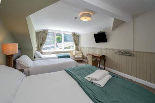 a hotel room with two beds and a television at Coach Hill House in Cork