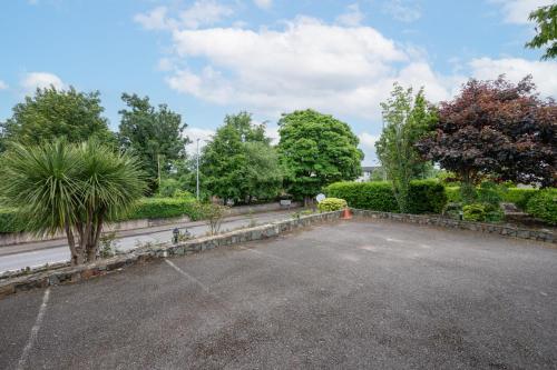 a parking lot in a park with trees and bushes at Coach Hill House in Cork