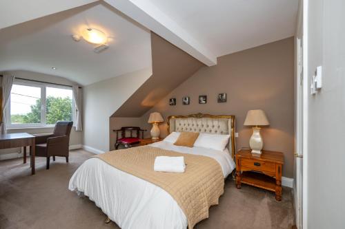 a bedroom with a bed and a desk and a window at Coach Hill House in Cork