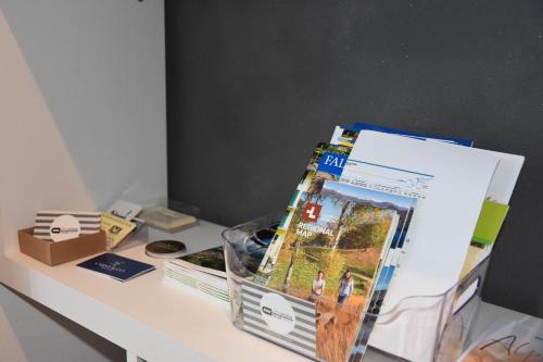 a table with books and magazines on it at ZARA HOUSE - Lake and Pet Friendly in Brusimpiano