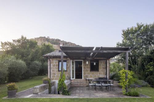 a stone house with a table and chairs in a yard at Sant'Anselmo in Bagnoregio