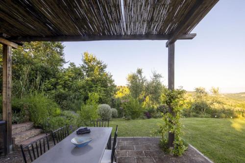 a patio with a table and chairs in a garden at Sant'Anselmo in Bagnoregio