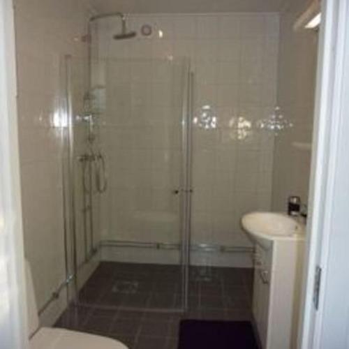 a bathroom with a shower and a toilet and a sink at Høystandard feriehytte, Utendørs boblebad, sauna in Filipstad