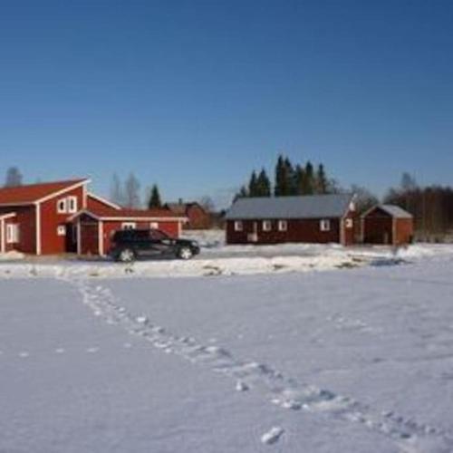a car footprints in the snow in front of buildings at Høystandard feriehytte, Utendørs boblebad, sauna in Filipstad