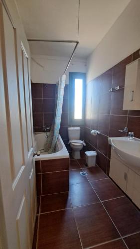 a bathroom with a tub and a toilet and a sink at Hercules Hills Sea View Villas in Kos