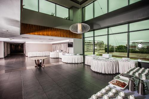 a banquet hall with white chairs and tables and windows at Coastlands Umhlanga Hotel and Convention Centre in Durban