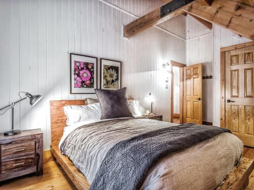 ein Schlafzimmer mit einem großen Bett und einer Holztür in der Unterkunft Le Mont-Tremblant - Résidences Boutique in Lac-Superieur