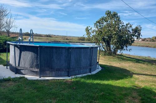 - une piscine dans l'herbe à côté d'une masse d'eau dans l'établissement MOULIN DE MAUZAC - Gîte Cap Océan, à Saint-Just