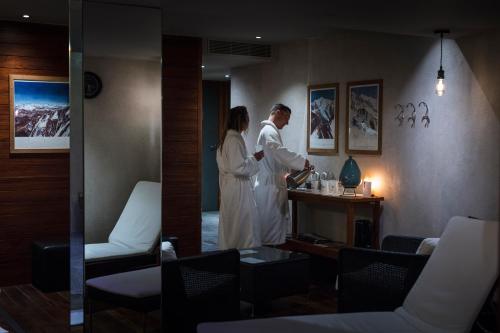 a man and a woman standing in a room at Le Hameau Albert 1er - Relais & Châteaux in Chamonix