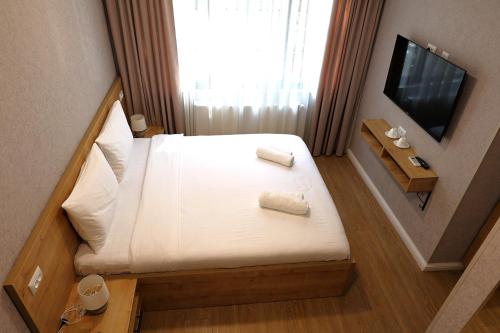 a small hotel room with a bed and a television at Greenwood in Borjomi