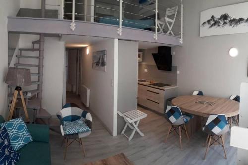 Cette chambre comprend une mezzanine, une table et des chaises. dans l'établissement Aigle-Royal Cauterets, appartement RDC 4-6 pers, à Cauterets