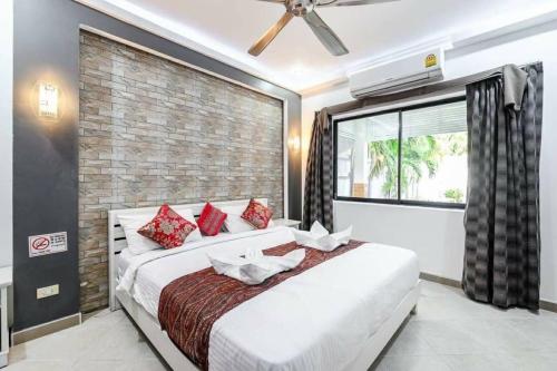 Un dormitorio con una cama grande y una pared de ladrillo. en MM Pool Villa, en Pattaya South