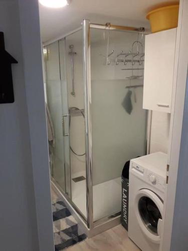 une salle de bain avec une machine à laver et un lave-linge dans l'établissement Aigle-Royal Cauterets, appartement RDC 4-6 pers, à Cauterets