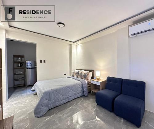 a bedroom with a bed and a blue couch at F Residence Transient House in Cabanatuan