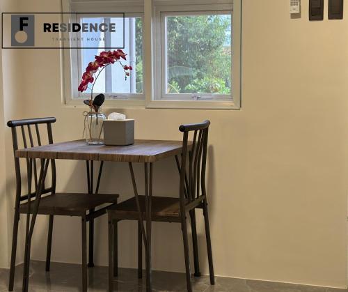 a dining room table with two chairs and a window at F Residence Transient House in Cabanatuan