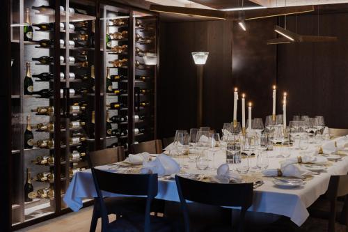 a dining room with a long table with chairs and wine racks at No 14 Verbier in Verbier