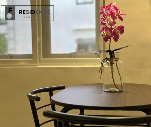 a vase of flowers sitting on a table with a chair at F Residence Transient House in Cabanatuan