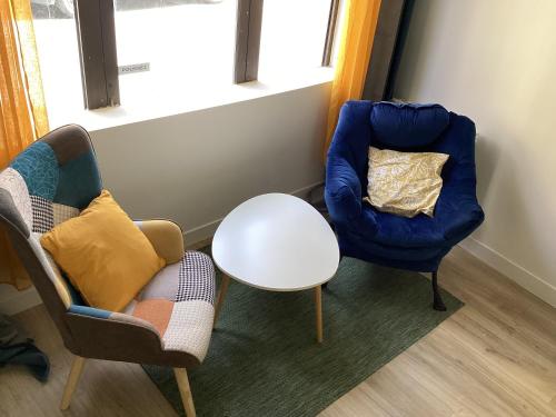 a living room with two chairs and a table at A3 Bel appartement lumineux au Rdc in Évaux-les-Bains