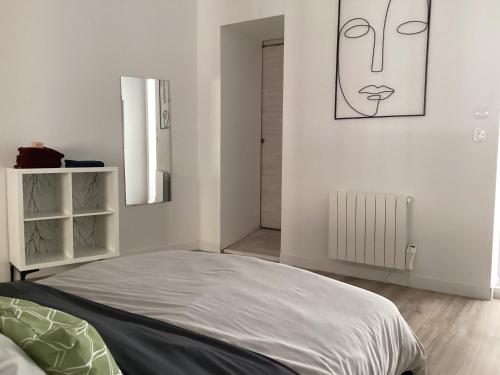 a bedroom with a bed and a picture of a face on the wall at A3 Bel appartement lumineux au Rdc in Évaux-les-Bains