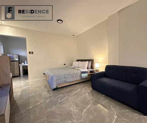 a bedroom with a bed and a couch at F Residence Transient House in Cabanatuan