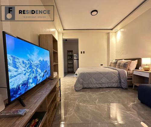 a bedroom with a large flat screen tv and a bed at F Residence Transient House in Cabanatuan