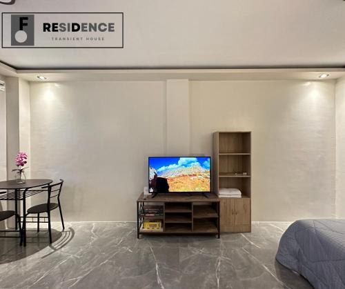 a bedroom with a tv and a table and a bed at F Residence Transient House in Cabanatuan