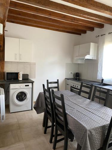 une cuisine avec une table et des chaises dans une cuisine dans l'établissement Hébergement La Chaumière de Rambouillet 1-6 pers, à Rambouillet