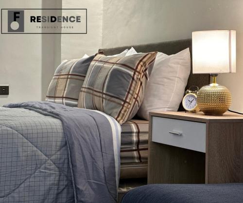 a bedroom with a bed and a couch with pillows at F Residence Transient House in Cabanatuan
