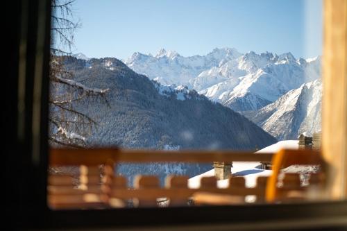 a view of a snowy mountain range from a window at No 14 Verbier in Verbier