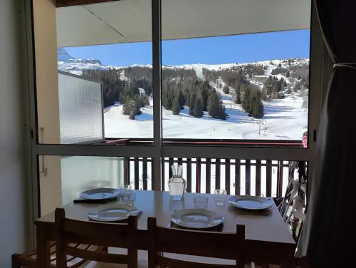 a dining room table with a view of a ski slope from a window at Studio 4 personnes Sud rénové - pied des pistes in Superdevoluy