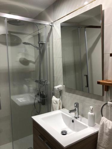 a bathroom with a sink and a shower with a mirror at Apartamento en Benicassim. in Benicàssim