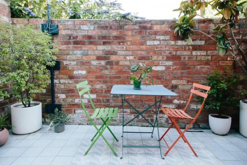 a table and chairs in front of a brick wall at Cute 1 bed Townhouse in Jericho in Oxford