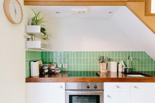 a kitchen with green tile on the wall at Cute 1 bed Townhouse in Jericho in Oxford