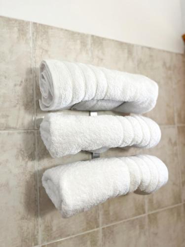 a bunch of white towels on a towel rack in a bathroom at Room 4 in Loutra Oraias Elenis 