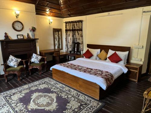ein Schlafzimmer mit einem Bett und einem Tisch und Stühlen in der Unterkunft Dalhousie Heritage Cottage in Nainital