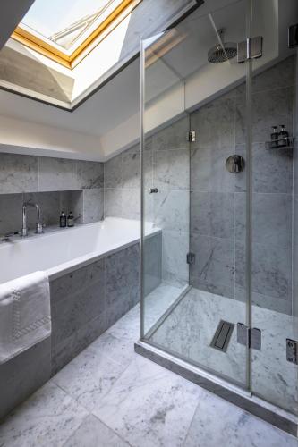 a bathroom with a tub and a glass shower at No 14 Verbier in Verbier