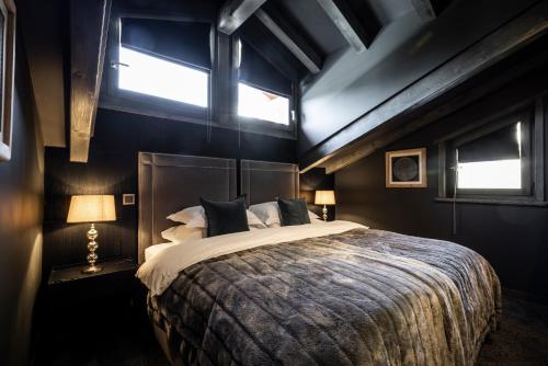 a bedroom with a large bed and two windows at No 14 Verbier in Verbier
