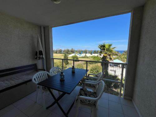 une table et des chaises sur un balcon avec vue dans l'établissement Duplex vue mer à Piana Verde Canale-di-verde, à Canale-di-Verde