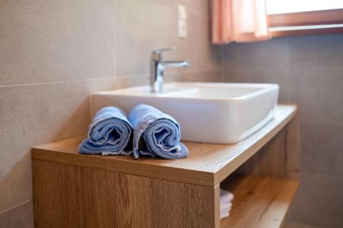 a bathroom with a sink and towels on a counter at Residence Obermoarhof - Family Apartments with Pool & Playground in Vandoies
